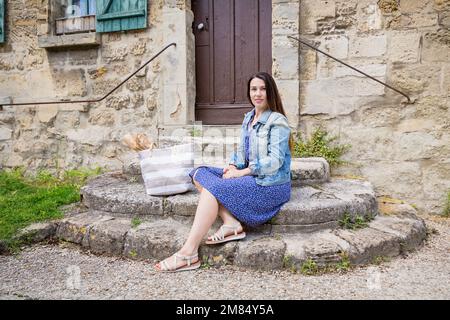 Attractive young woman sitting and posing on ancient stone stairs outdoor Stock Photo