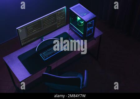 Top view of home coder workspace with professional programming setup. Empty IT specialist studio in neon light. Copy space.  Stock Photo