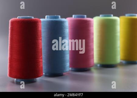 Multicolored thread spools on gray background. Set of colored threads Stock Photo