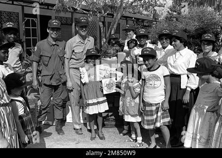 Chaplain (LT.) Thomas Murphy and another crew member from the battleship USS IOWA (BB-61) pose with Sister Teresita Rodriguez, mother superior, and other residents of the Hogar Cristiano Orphanage during a presentation of Projects Handclasp material. The project is part of a civic action project. Base: Punterenas Country: Costa Rica (CRI) Stock Photo