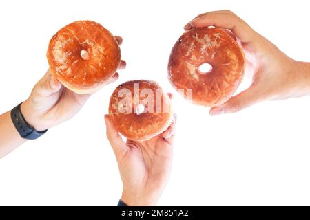 Different hands holding glazed doughnuts in different angles Stock Photo