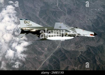 An air-to-air right underside view of a 497th Tactical Fighter Squadron F-4E Phantom II aircraft banking to the left during exercise Team Spirit '86. The aircraft is armed with an AIM-9 Sidewinder missile. Subject Operation/Series: TEAM SPIRIT '86 Country: South Korea Stock Photo