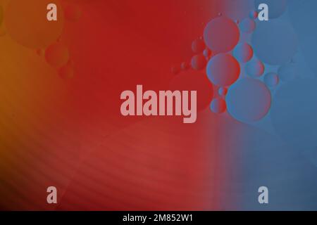 Colorful oil drops on water surface. Abstract red blue yellow macro background. Stock Photo