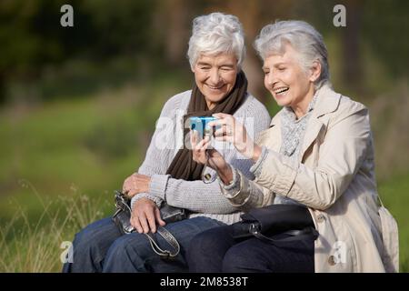 Lets take one more...Two senior women using a digital camera with a smile. Stock Photo