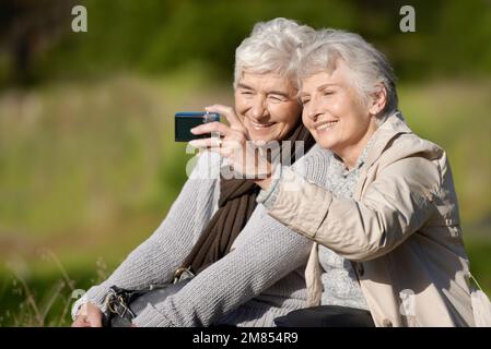 Lets take one more...Two senior women using a digital camera with a smile. Stock Photo