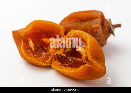 Half dried persimmon on a white background Stock Photo