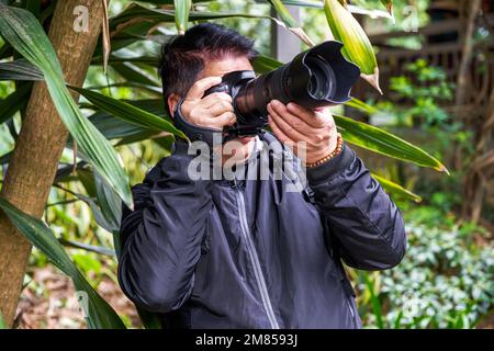 A photographer is using a SLR camera to create a shot Stock Photo
