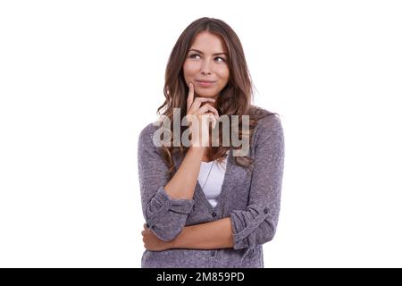 Thinking about the day ahead. A young woman thinking against a white background. Stock Photo