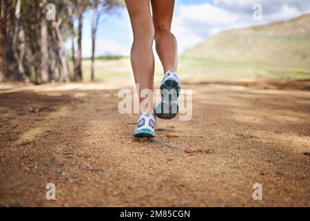 Going for a trail run. Cropped view of a womans legs running through a ...