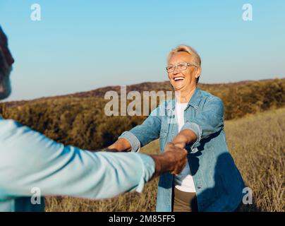 woman man outdoor senior couple happy lifestyle retirement together smiling love dancing nature mature Stock Photo