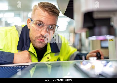 Engineer sitting in robot fabrication room use measuring microscope machine check electronic board Stock Photo