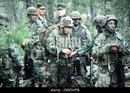 Marines armed with M-16A2 rifles stop to regroup while on patrol during rapid response loading exercise Agile Sword '86. Standing front, left, is a marine armed with an M-249 Squad Automatic Weapon (SAW) and front, right, a Marine armed with an M-16A2 rif. Subject Operation/Series: AGILE SWORD '86 Base: Naval Air Station, Pensacola State: Florida (FL) Country: United States Of America (USA) Stock Photo