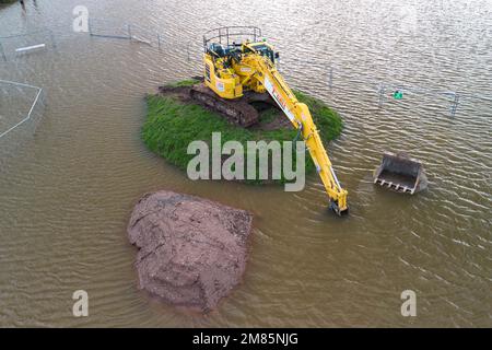 Upton-upon-Severn, Worcestershire, January 12th 2023 - A small Worcestershire town has been flooded after the River Severn burst its banks due to rising water levels. A waste recycling centre has been closed along with a local access road, Hanley Road, which has been closed by the local council. A large yellow digger was also seen marooned on a small grassy mound as the flooding surrounded it. Credit: Stop Press Media/Alamy Live News Stock Photo