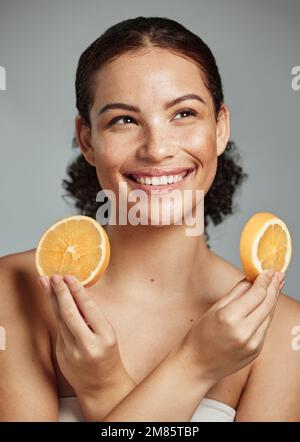 Model, orange and hands in studio for skincare, health and wellness for cosmetic glow, self care and backdrop. Black woman, fruit aesthetic and diet Stock Photo