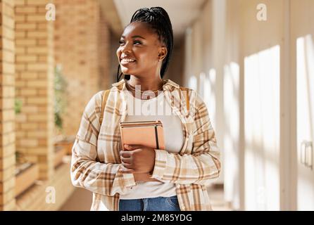 Black woman, college student and thinking about future with books while walking at campus or university. Young gen z female happy about education Stock Photo