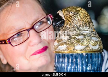 London, UK. 12th Jan, 2023. The Antiques Enamel Company selling a silver-gilt Parrot cocktail shaker by Wolfer's Bros and retailed by Chaumet, £15,000. It was previously owned by Lady Victoria White of Victoria's Secret fame - The Mayfair Antiques & Fine Art Fair, London Marriott Hotel Grosvenor Square. Credit: Guy Bell/Alamy Live News Stock Photo