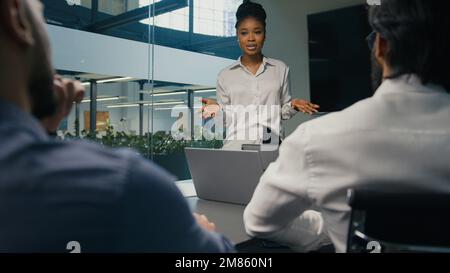 African American businesswoman mentor business coach company CEO female leader teaching business team multiracial diverse coworkers present startup Stock Photo