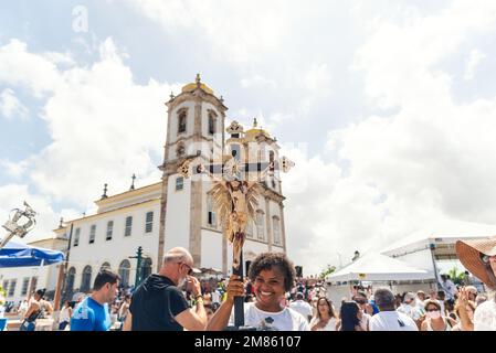 Salvador, Bahia, Brazil - January 06, 2023: Catholics touching the image of Jesus Christ during mass at Senhor do Bonfim church, in the background, in Stock Photo