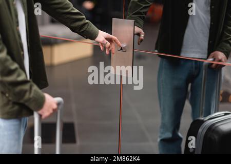 partial view of man pressing call button of elevator with reflective doors in hotel,stock image Stock Photo