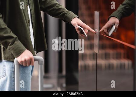 cropped view of man with mobile phone pressing elevator call button in hotel,stock image Stock Photo