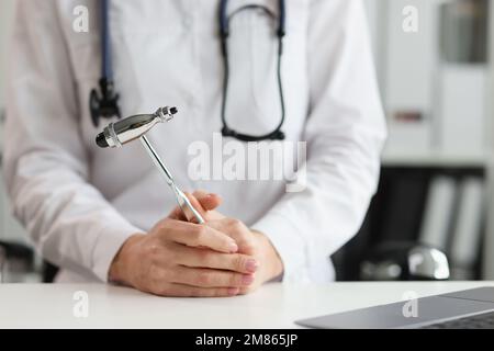 Doctor neurologist with hammer in hands in clinic. Neuropathologist is doctor who treats diseases and lesions of human nervous system Stock Photo