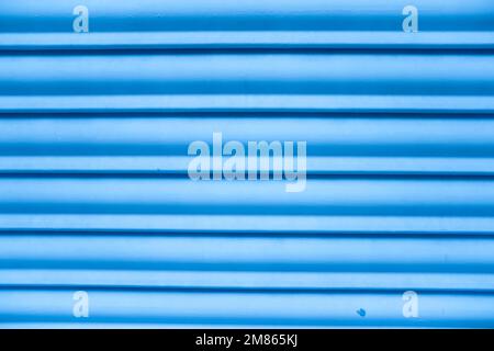 Close-up of a closed blue blind that forms a texture of horizontal lines Stock Photo