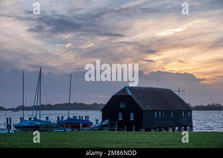 Raptackle wooden hut in Bosham West Sussex England with the sun going down in the background Stock Photo