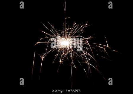 Burning sparkler isolated on black background. Fireworks theme. Light effect and texture. Christmas and new year decoration. Stock Photo
