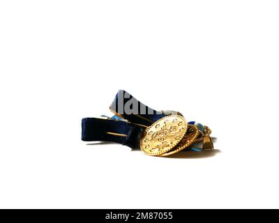 Souvenir gold jewelry with the Ottoman monogram or tugra on it.  Isolated golden gift. Stock Photo