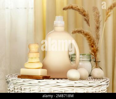 Natural laundry detergent mockup. Washing detergent concept with bottle of washing gel or fabric softener on a white laundry basket with natural soap, Stock Photo
