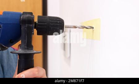 Close up shot of hand drill near the wall, decorating house. High quality photo Stock Photo