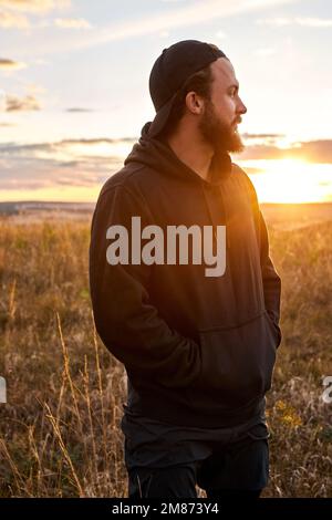 Young guy in black wear having rest outdoors, in nature. Male after sport, enjoy the rest. Relaxed man jogger, leisure after training. outdoor portrai Stock Photo