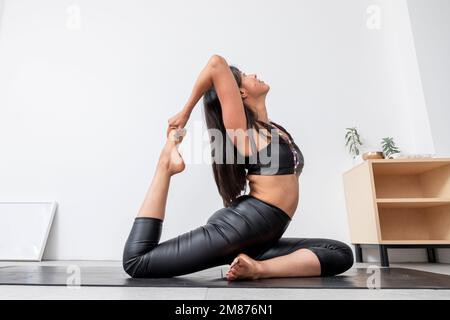 Premium Photo  Flexible slim woman in tracksuit exercises yoga poses at  karemat watches instructional videos on tablet leans away keeps arm raised