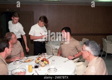 A messman takes meal orders from officers in the wardroom aboard the nuclear-powered aircraft carrier USS THEODORE ROOSEVELT (CVN 71). Base: USS Theodore Roosevelt (CVN 71) Stock Photo