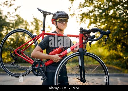 Cyclo cross competition member Man biker carrying bike up on going on road Professional road bicycle racer. Strong athletic man in sportswear and prot Stock Photo Alamy