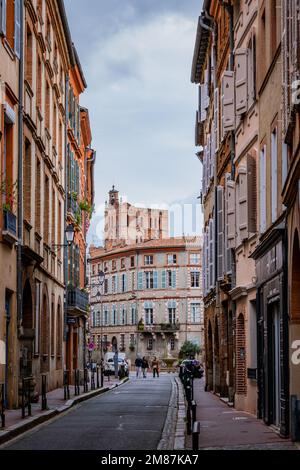 Beautiful facades with bricks in Perchepinte street and the Saint Etienne cathedral bell tower in Toulouse old town, in the south of France (Haute Gar Stock Photo