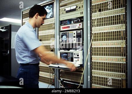 Data Processing Technician 2nd Class Holt monitors a telecommunications console in response to a user trouble call in the Navy Regional Data Automatic Center. Base: Naval Air Station, Jacksonville State: Florida (FL) Country: United States Of America (USA) Stock Photo