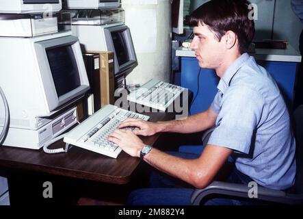 Data Processing Technician 2nd Class Trotter uses a computer terminal to check on a job in progress at the Navy Regional Data Automatic Center. Base: Naval Air Station, Jacksonville State: Florida (FL) Country: United States Of America (USA) Stock Photo