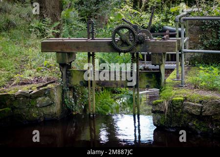 An old wooden sluice gate in a small stream in Calder Vale, Lancashire, England Stock Photo