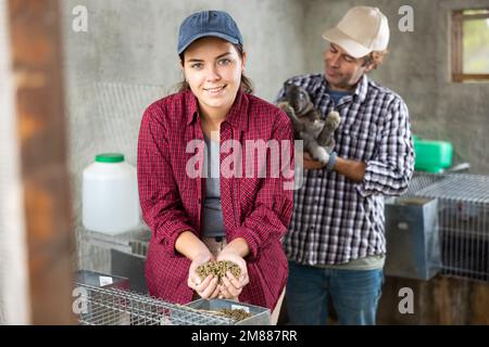 Family business - man and woman breed rabbits on farm Stock Photo - Alamy