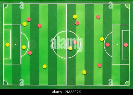 High angle shot of a soccer game strategy with red and yellow colored circular field and figures on a blackboard. Stock Photo