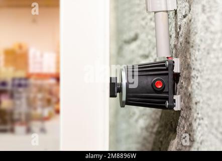 Close up electromagnetic lock mounted on an aluminum fire door to restrict access to warehouse or factory Stock Photo