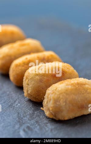 Close up of homemade croquette, typical spanish black slate dish. Stock Photo