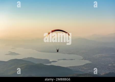 Paragliding from Babadag Mountain at Sunset overlooking Oludeniz near Fethiye in Turkey Stock Photo