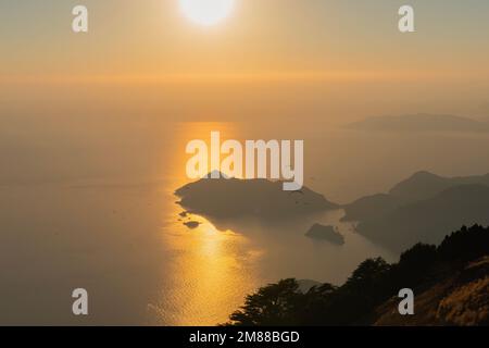 Paragliding from Babadag Mountain at Sunset overlooking Oludeniz near Fethiye in Turkey Stock Photo