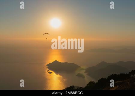 Paragliding from Babadag Mountain at Sunset overlooking Oludeniz near Fethiye in Turkey Stock Photo