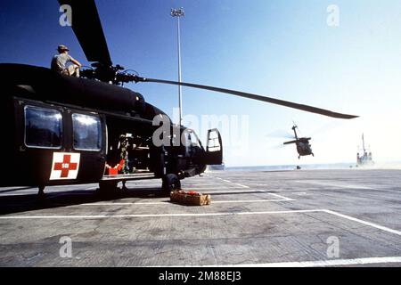 A UH-60 Blackhawk helicopter takes off as another stands by after offloaded from the cargo ship LYRA. The helicopters are being deliverd for use during SHADOW HAWK, the segment of the multiservice Exercise BIRGHT STAR '87 that tests joint Jordan-US operations. Subject Operation/Series: SHADOW HAWKBRIGHT STAR Base: Aqaba Country: Jordan (JOR) Stock Photo