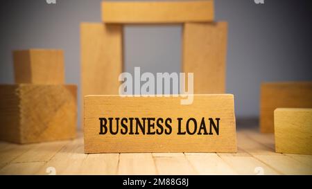 Business loan text. It is written on a wooden surface. The background is white Stock Photo