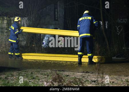 Erkelenz, Germany. 13th Jan, 2023. THW employees stack material to shore up a building where two people are holed up in a tunnel. Credit: David Young/dpa/Alamy Live News Stock Photo