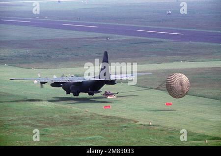 A 37th Tactical Airlift Squadron C-130E Hercules aircraft makes a grass  strip landing at Drop Zone Juliet near Aviano Air Base during an evening  training mission. Country: Italy (ITA Stock Photo 